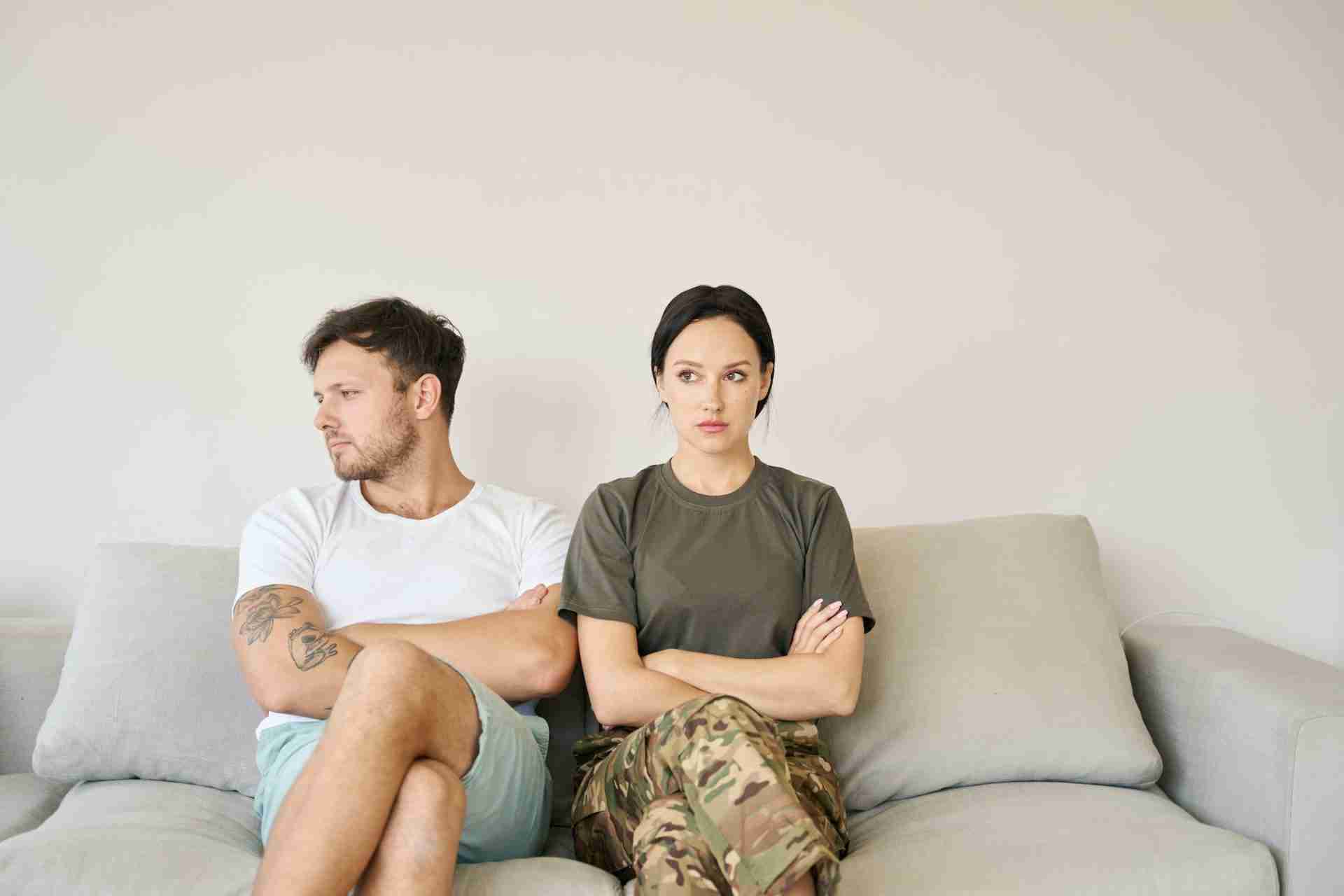 Conflicting Couple Sitting On Sofa In Closed Poses